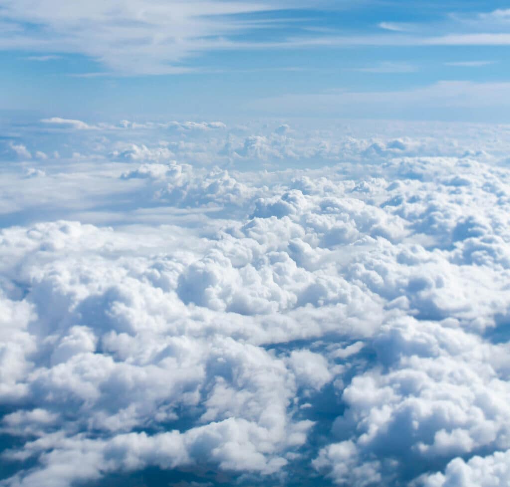 A deck of cumulus cloud seen from above from the cockpit of an aircraft in cruise, with clear blue sky over the top of it.